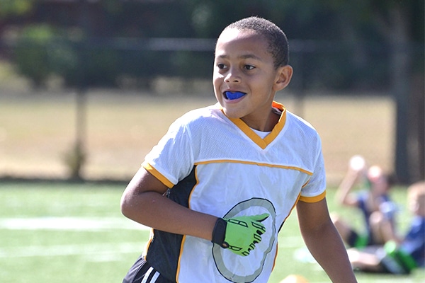 Young athlete wearing mouthguard on sports field during daytime game