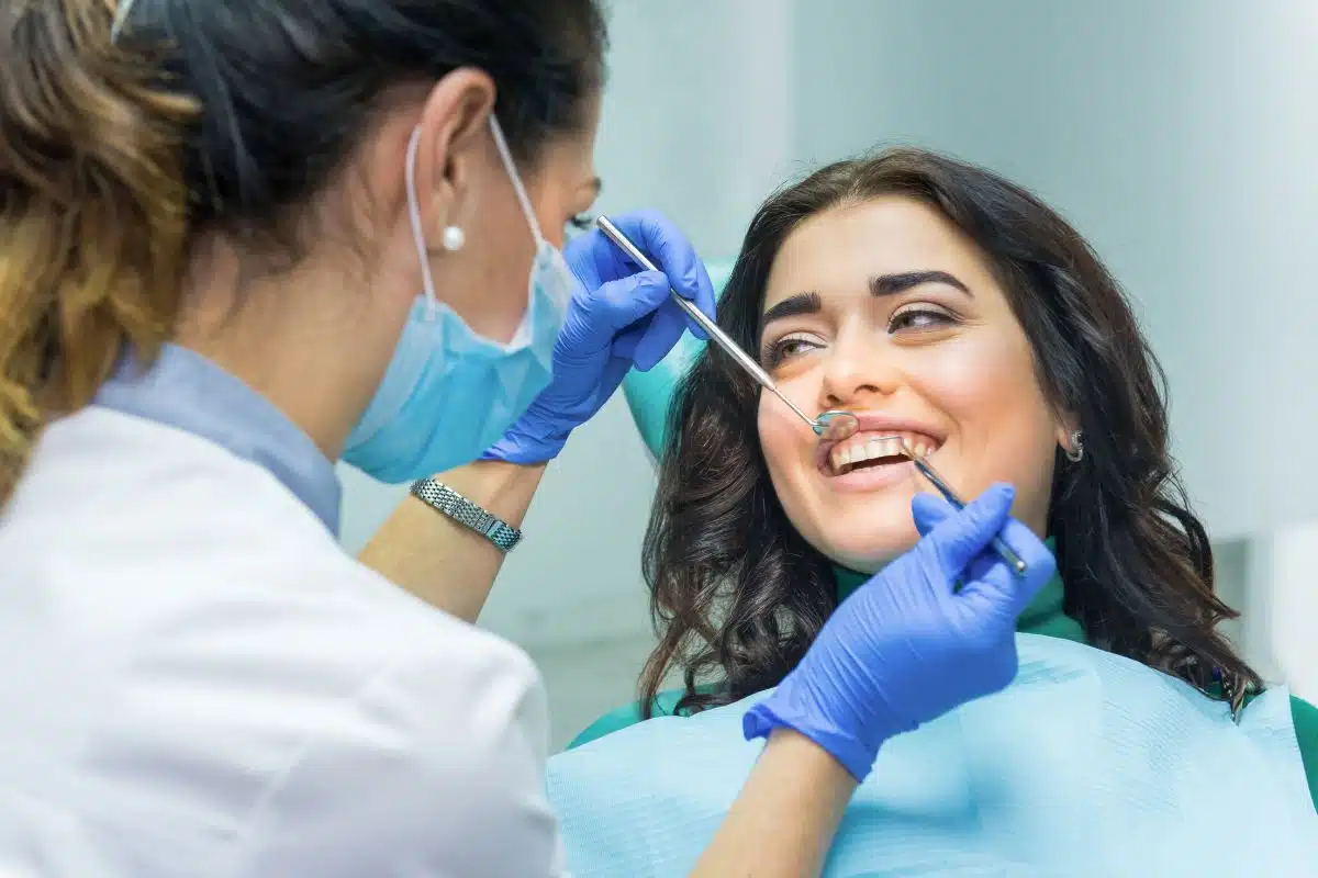 Dentist examining patient's teeth during a cosmetic dental treatment appointment.
