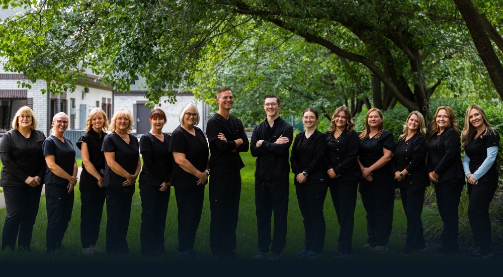 Brighton Healthy Smiles dental team standing together outdoors in professional black attire.